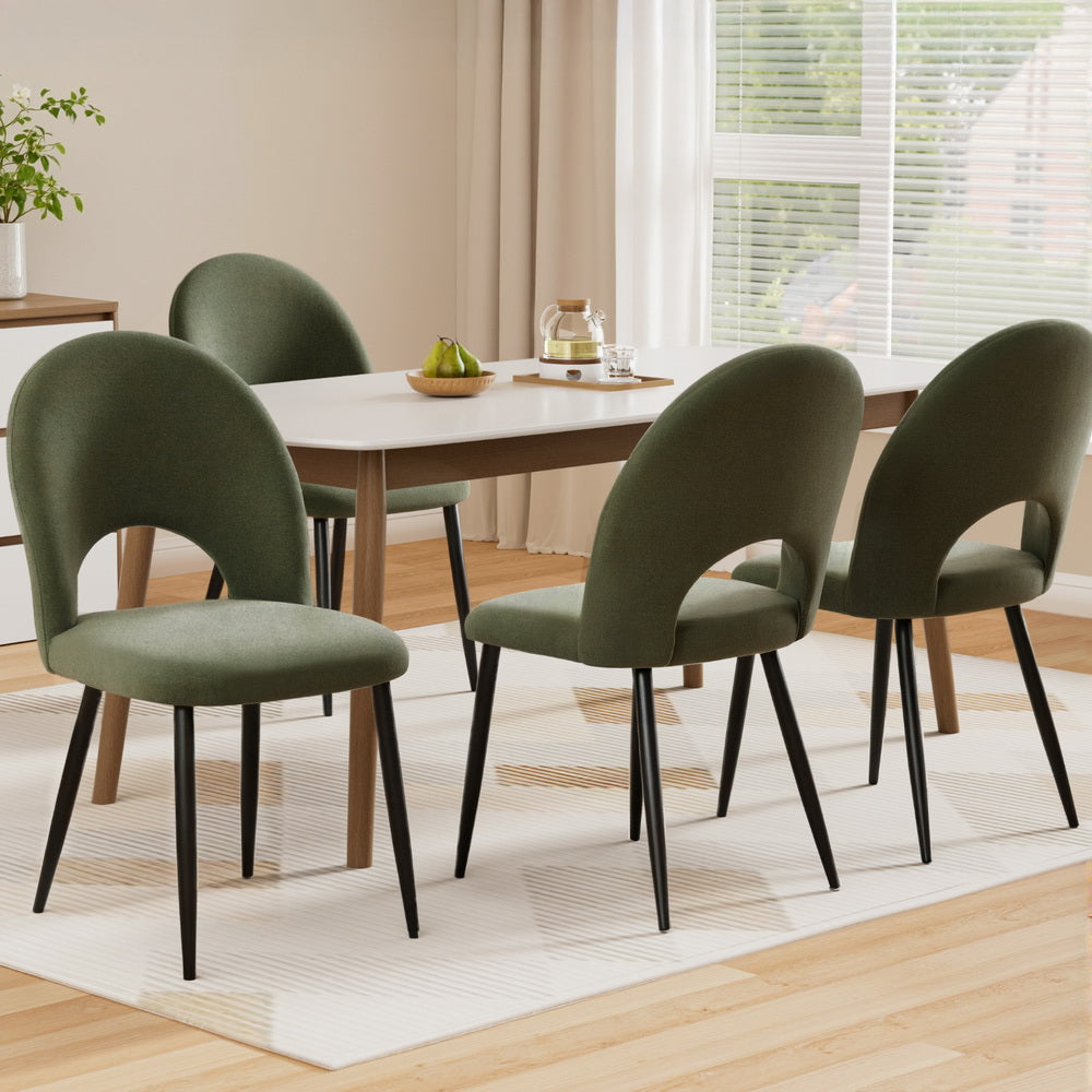 Dining room with a table and four green chairs.