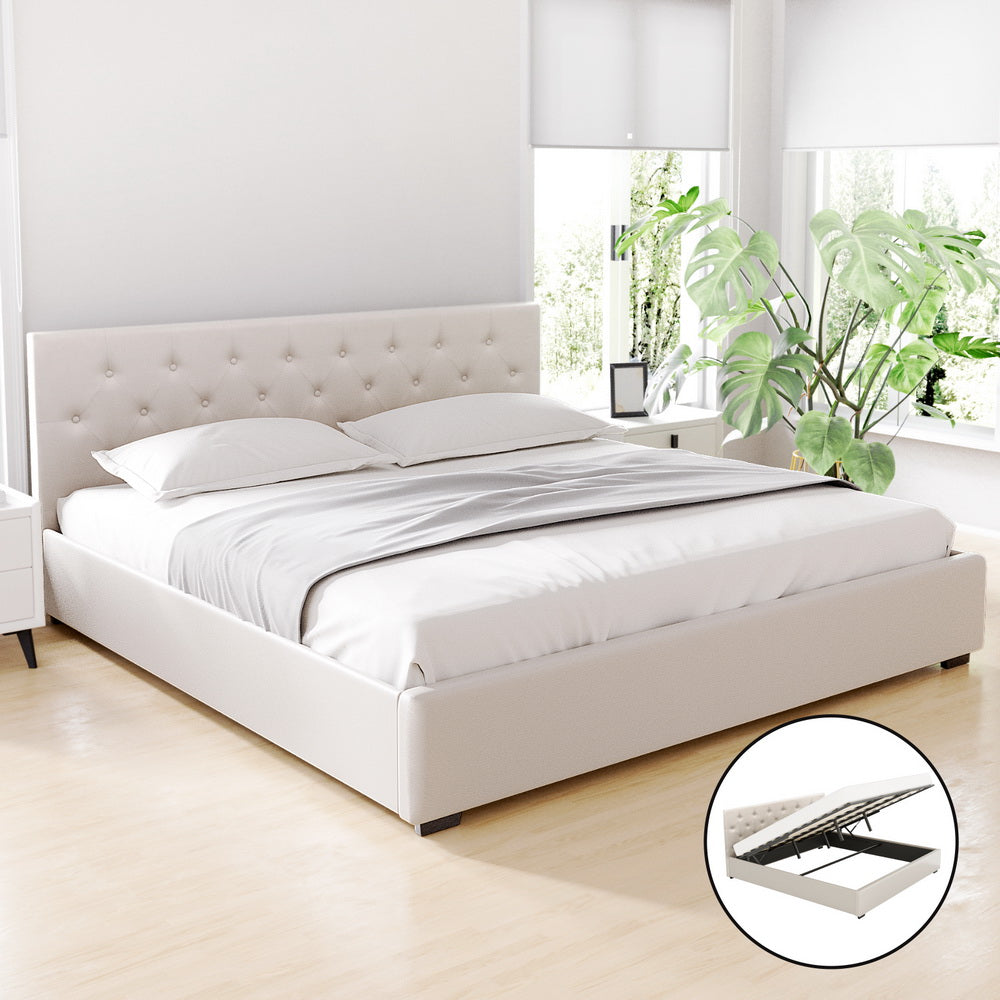 White upholstered bed in a bright bedroom with plants