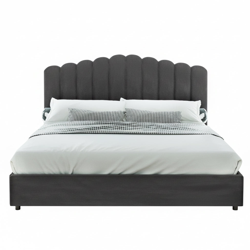 Gray upholstered bed with white bedding in a room with plants and a window.