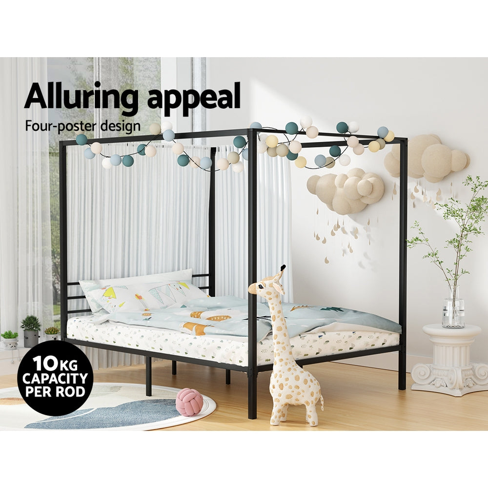 Children's four-poster bed with bedding and a giraffe toy in a room setting.