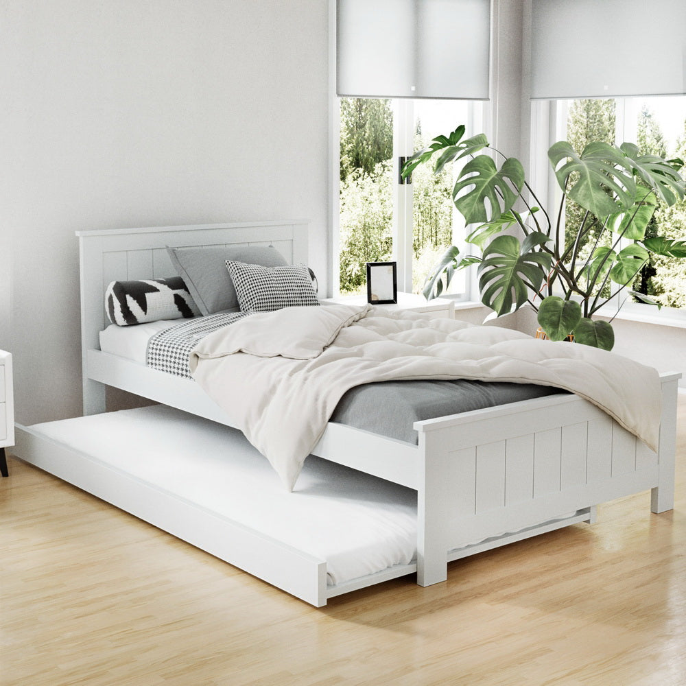 White bed with pull-out trundle in a bright room with plants